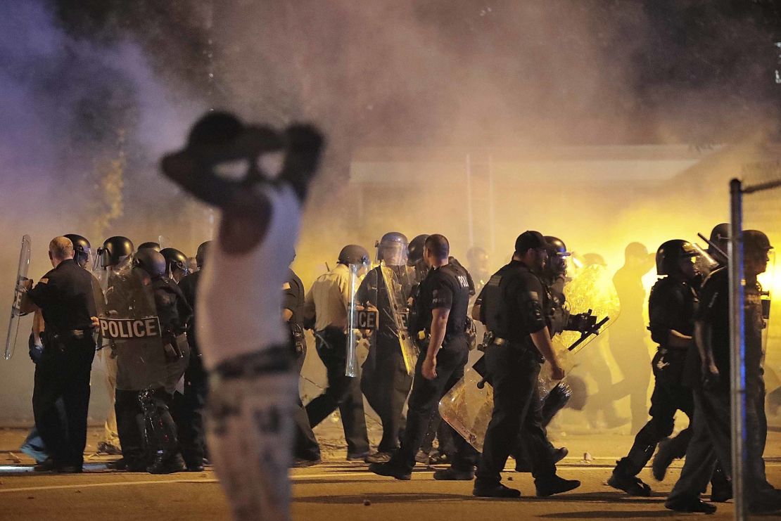 Police retreat under a cloud of tear gas as protesters disperse from the scene in Frayser. 