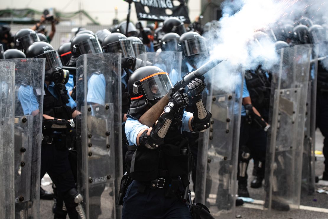 A police officer fires tear gas during clashes with protesters during a rally against a controversial extradition law proposal outside the government headquarters in Hong Kong on June 12, 2019.