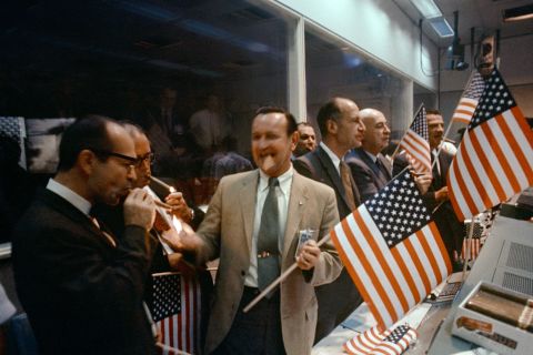 NASA officials and flight controllers celebrate the successful conclusion of the mission.