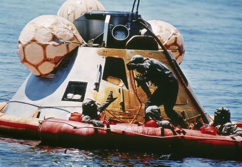 US Navy personnel assist the astronauts after their re-entry vehicle landed safely in the Pacific Ocean on July 24, 1969.