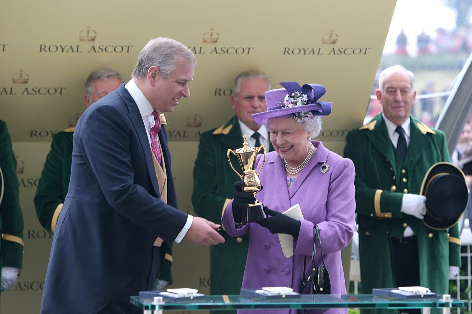 Prince Andrew, the Duke of York, presents Queen Elizabeth with a trophy after her horse Estimate won the Gold Cup in 2013.