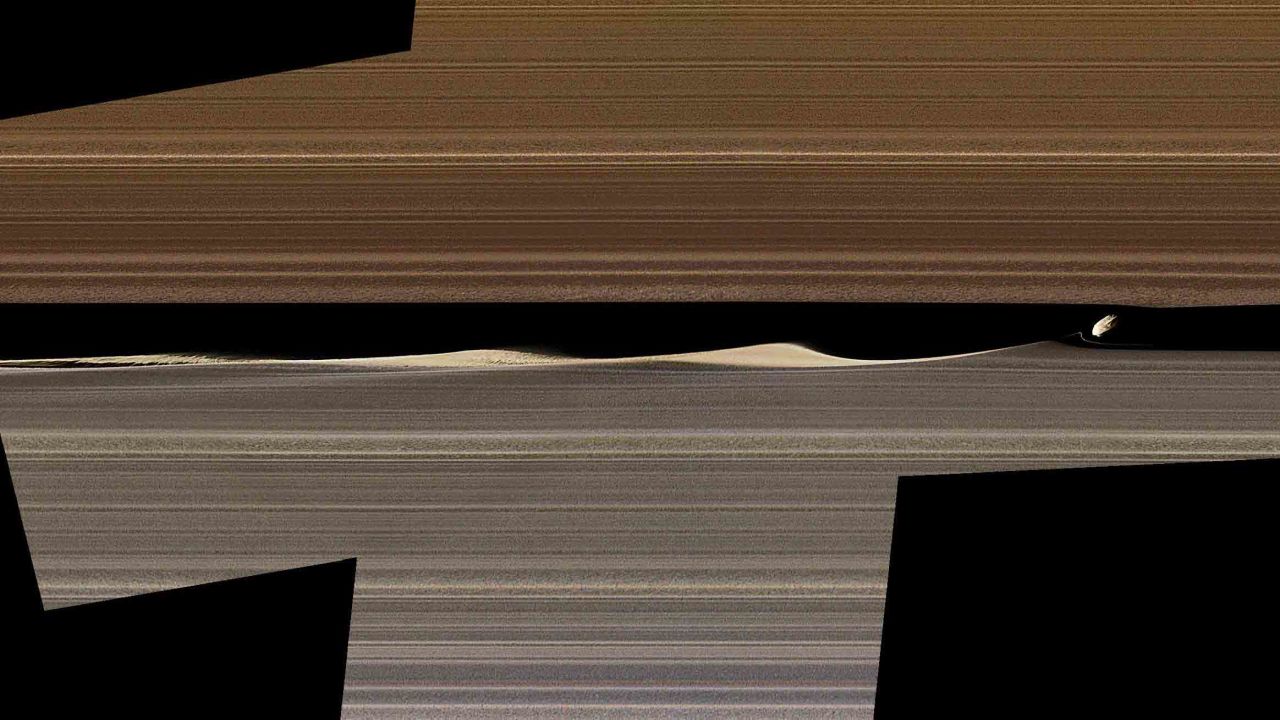 In between Saturn's rings on the right is Daphnis, one of Saturn's ring-embedded moons, and the waves it kicks up in the Keeler gap. 