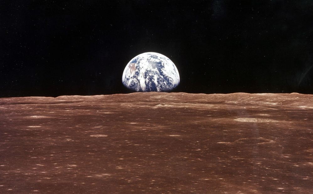 A view of Earth appears over the lunar horizon as Apollo 11's command module comes into view of the moon.