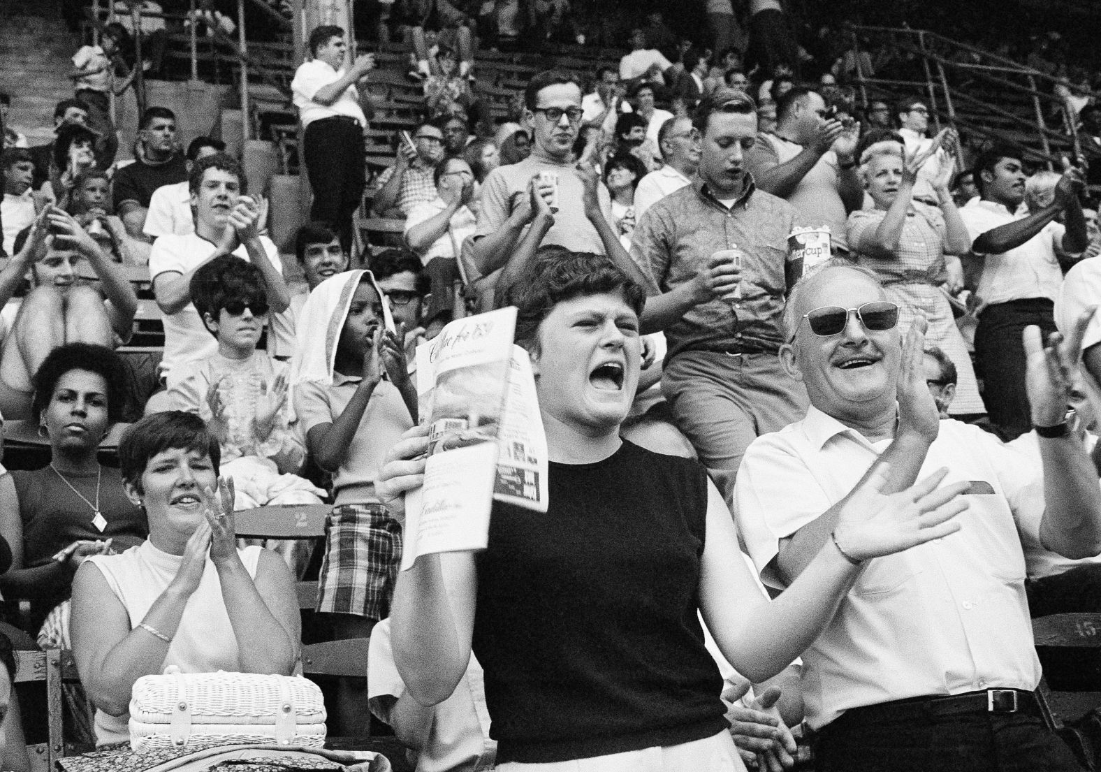 Fans attending a Philadelphia Phillies baseball game cheer after it was announced that the Eagle had made a safe lunar landing on July 20, 1969.