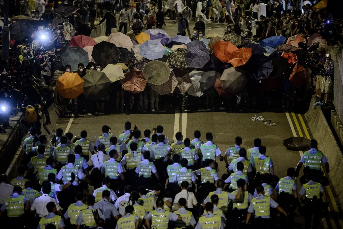 Police forces march toward pro-democracy protesters during a standoff outside the central government offices in Hong Kong on October 14, 2014. 