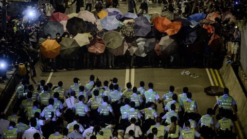 Police forces march toward pro-democracy protesters during a standoff outside the central government offices in Hong Kong on October 14, 2014. 