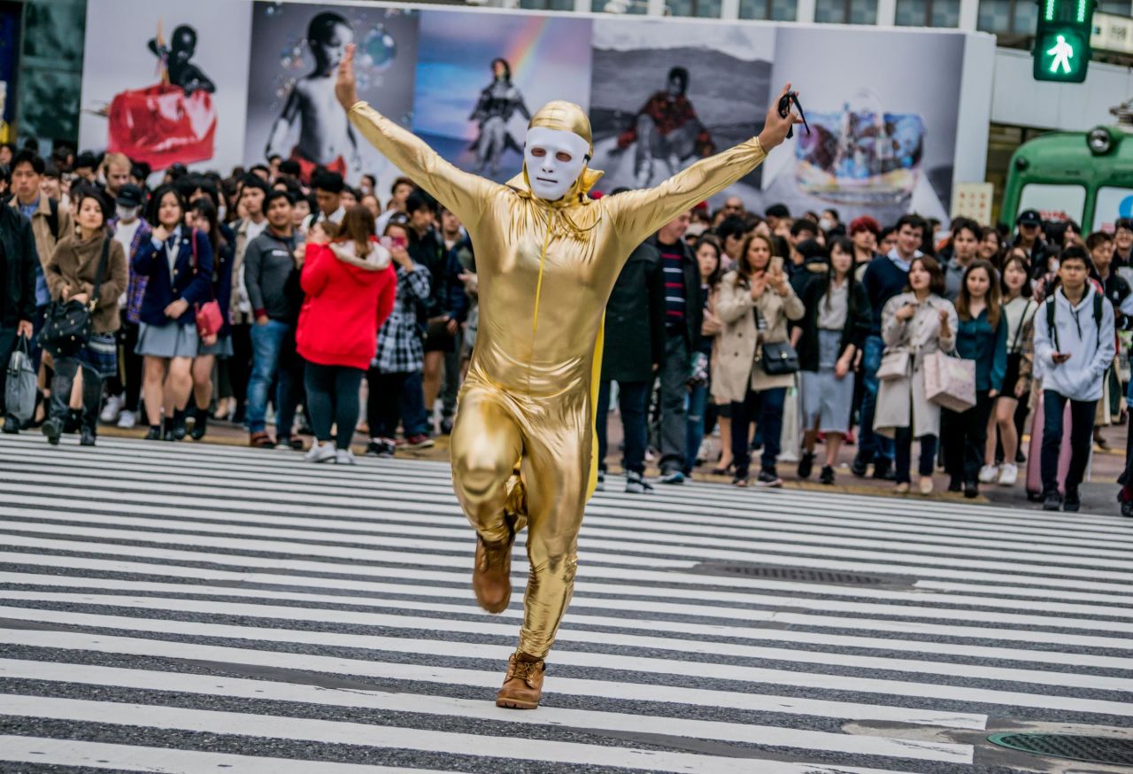 <strong>Limelight: </strong>A man dressed in gold satin skips through Shibuya Crossing, because, why not?