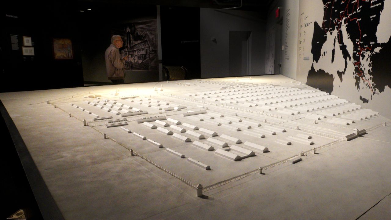 <strong>Taking in a massive site:</strong> This model shows the vast size and complexity of Auschwitz-Birkenau. Above it, a map explains the significance of the nearby railway line, which connected the complex to the rest of Europe. 