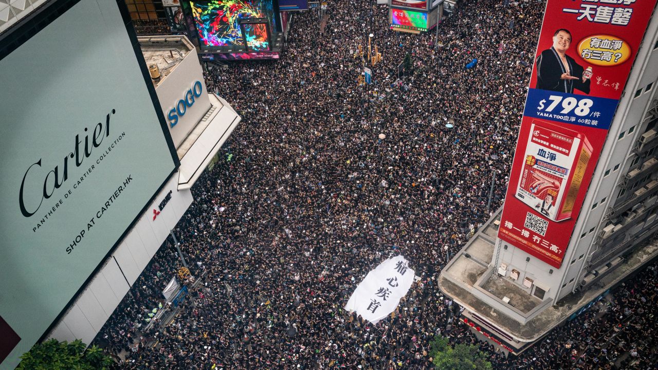 Protesters hold banners and shout slogans as they march on a street on June 16 in Hong Kong.