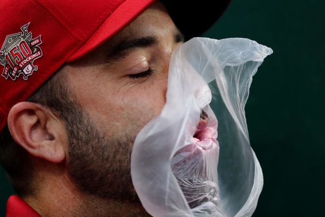 A member of the Cincinnati Reds' grounds crew loses his gum bubble on Friday, June 14.