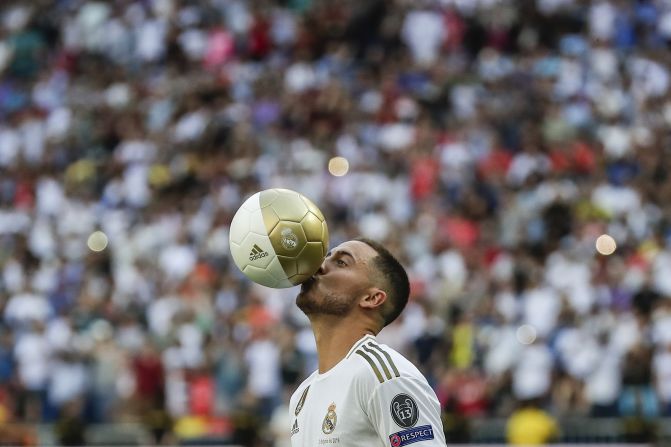 Belgian forward Eden Hazard kisses the ball as he is revealed as <a href="index.php?page=&url=https%3A%2F%2Fwww.cnn.com%2F2019%2F06%2F07%2Ffootball%2Feden-hazard-transfer-real-madrid-chelsea-spt-intl%2Findex.html" target="_blank">Real Madrid's newest signing</a> on Thursday, June 13. Madrid acquired the 28-year-old playmaker from Chelsea.