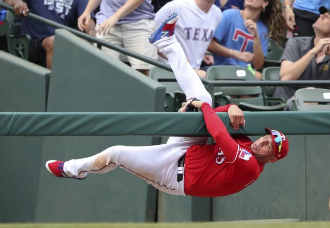 Texas Rangers third baseman Asdrubal Cabrera hangs on a railing after attempting to catch a foul ball during a Major League Baseball game against Oakland Athletics on Sunday, June 9. 