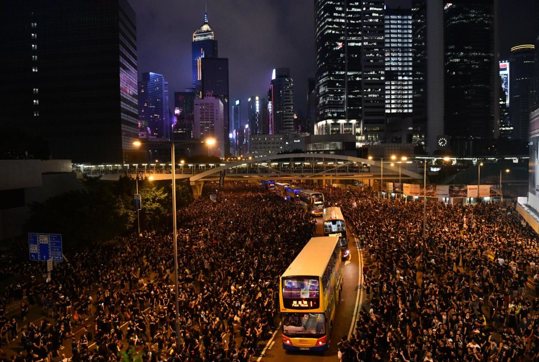 Buses drive through crowds of protesters outside the Legislative Council building as they demonstrate against the now-suspended extradition bill on June 16, 2019 in Hong Kong. 