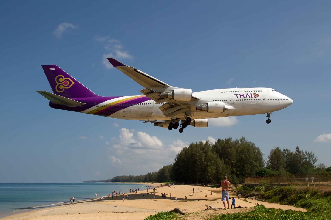 A Thai Airways Boeing 747-400 comes in for a landing over Phuket's Mai Khao beach.