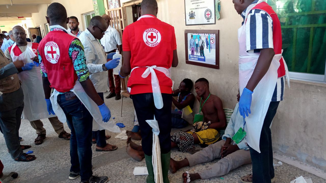 EDITORS NOTE: Graphic content / Red Cross officials attend to some victims injured in the Konduga bombings on Monday.