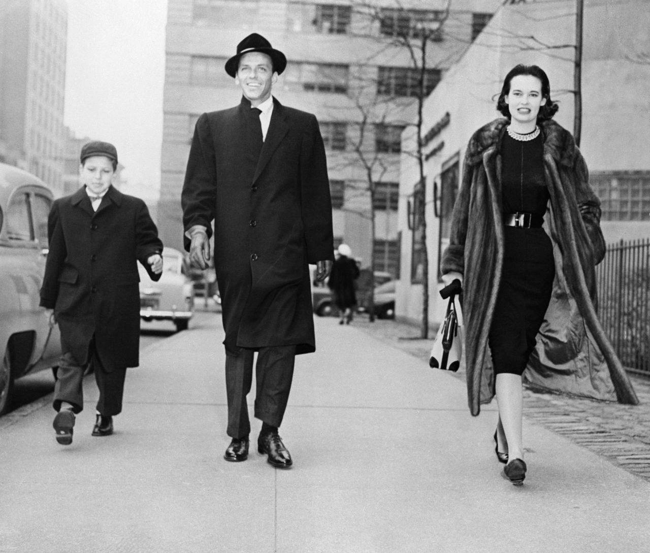 Vanderbilt strolls with Frank Sinatra and Frank Sinatra Jr. The previous night, she had attended a New York stage premiere with Sinatra.