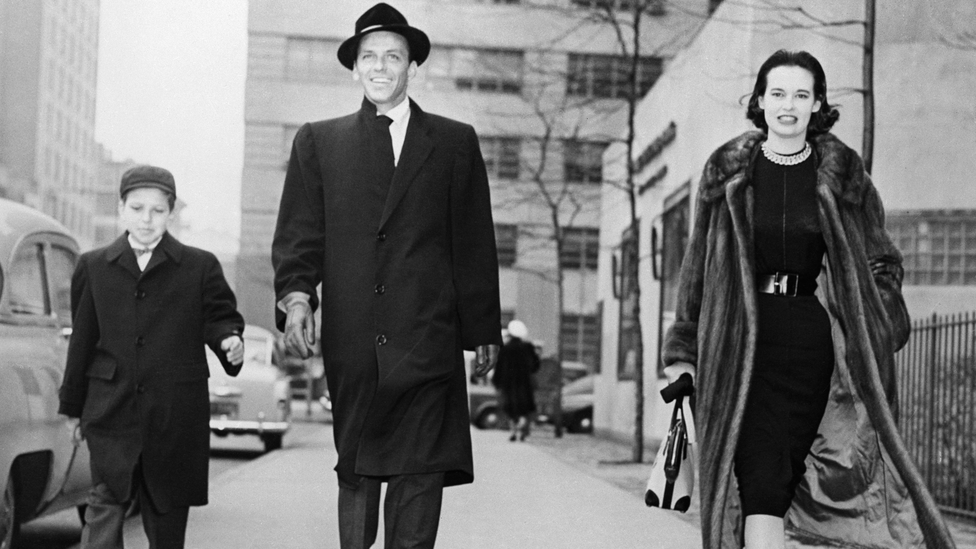 Vanderbilt strolls with Frank Sinatra and Frank Sinatra Jr. The previous night, she had attended a New York stage premiere with Sinatra.