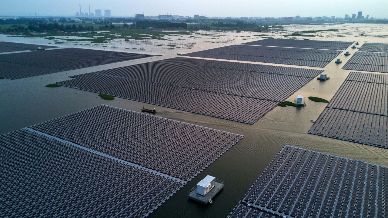 HUAINAN, CHINA - JUNE 13: Chinese workers ride in a boat through a large floating solar farm project under construction by the Sungrow Power Supply Company on a lake caused by a collapsed and flooded coal mine on June 13, 2017 in Huainan,  Anhui province, China. The floating solar field, billed as the largest in the world, is built on a part of the collapsed Panji No.1 coal mine that flooded over a decade ago due to over-mining, a common occurence in deep-well mining in China's coal heartland. When finished, the solar farm will be made up of more than 166,000 solar panels which convert sunlight to energy, and the site could potentially produce enough energy to power a city in Anhui province, regarded as one of the country's coal centers. Local officials say they are planning more projects like it, marking a significant shift in an area where long-term intensive coal mining has led to large areas of subsidence and environmental degradation. However, the energy transition has its challenges, primarily competitive pressure from the deeply-established coal industry that has at times led to delays in connecting solar projects to the state grid. Chinaas government says it will spend over US $360 billion on clean energy projects by 2020 to help shift the country away from a dependence on fossil fuels, and earlier this year, Beijing canceled plans to build more than 100 coal-fired plants in a bid to ease overcapacity and limit carbon emissions. Already, China is the leading producer of solar energy, but it also remains the planetas top emitter of greenhouse gases and accounts for about half of the worldas total coal consumption. (Photo by Kevin Frayer/Getty Images)