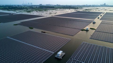 Chinese workers ride in a boat through a large floating solar farm project under construction by the Sungrow Power Supply Company in Huainan,  Anhui province, China. 