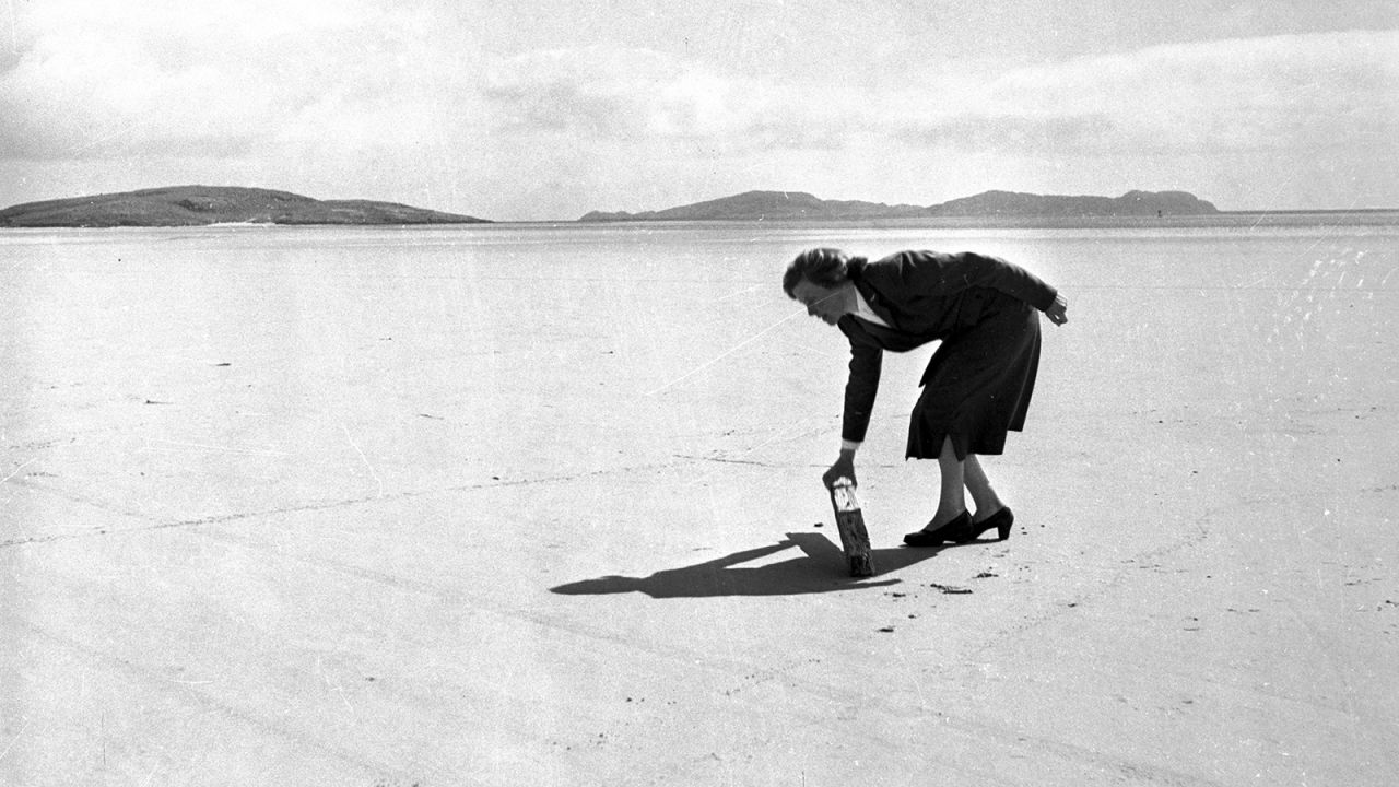 <strong>Clearing the runway: </strong>In 1957, airport manager Kitty MacPherson clears flotsam off the beach as she prepares Barra for another arrival. She ran the place single-handedly. <br />