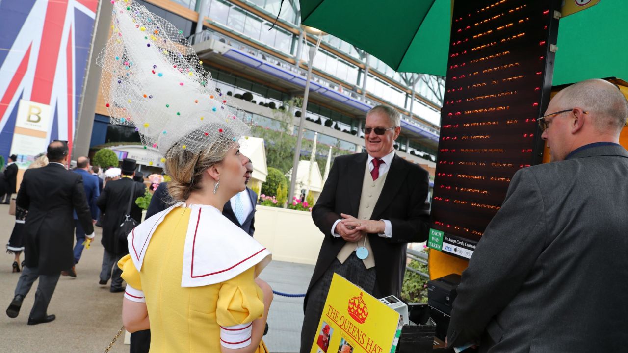 A racegoer bets on the Queen's hat color on day one of Royal Ascot.