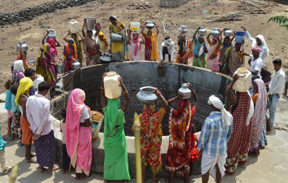 Indian women from the aboriginal 'Kol' community collect drinking water at a well in Nawargawa village, some 30km from Jabalpur, in Madhya Pradesh state on June 16.