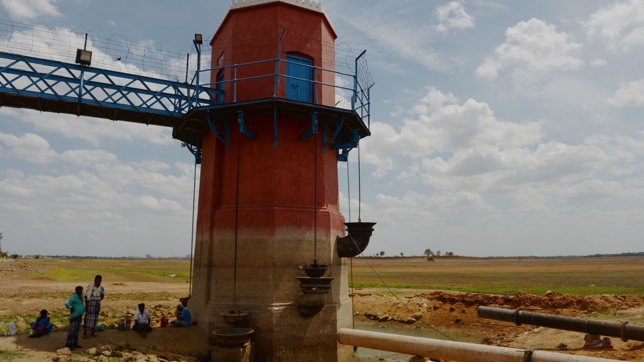 Men sit in the shade of a measuring tower at the dried-out Puzhal reservoir on the outskirts of Chennai on Friday.