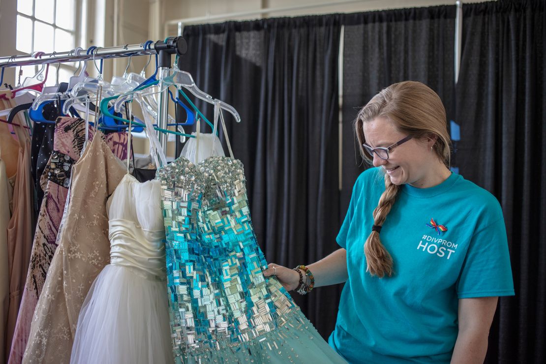 Aly Chapman looks through the garments in a dressing room filled with spare dresses and tuxedos for students to borrow.