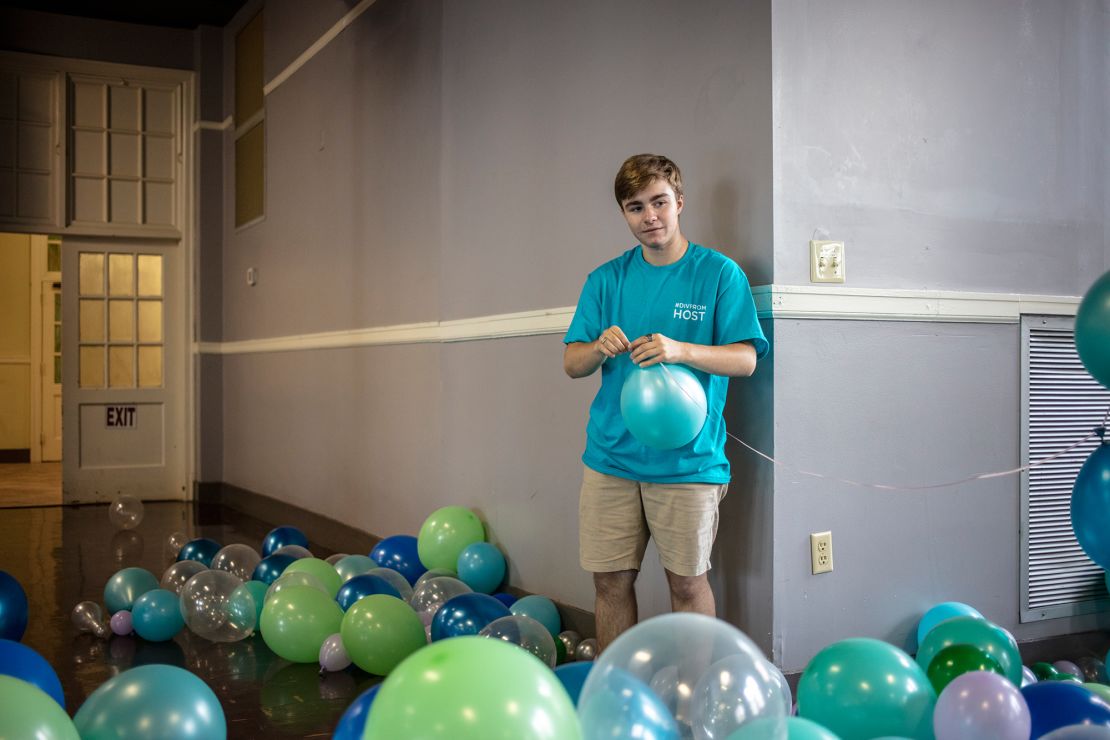 Fox strings together balloons to hang above the entryway into the prom.