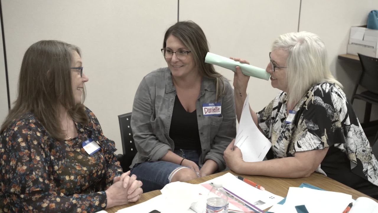 Peggy Oyer (right) takes part in a listening exercise that illustrates how someone hearing voices while experiencing a psychotic episode might feel.