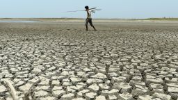 An Indian man walks over the parched bed of a reservoir on the outskirts of Chennai on May 17, 2017