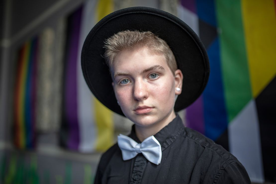 Kirby poses in front of the LGBTQ pride flags hung throughout the fellowship hall.