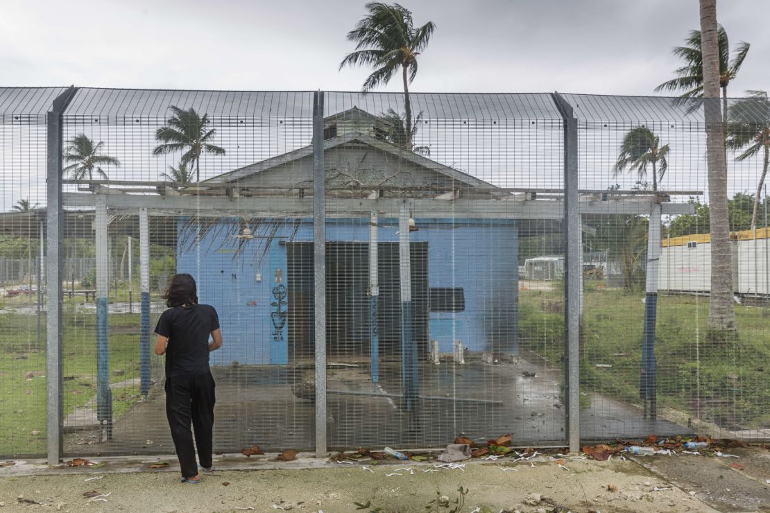 Asylum seeker Behrouz Boochani stands outside the abandoned naval base on Manus island, where he and other asylum seekers were locked up for the first three years of their dentention.