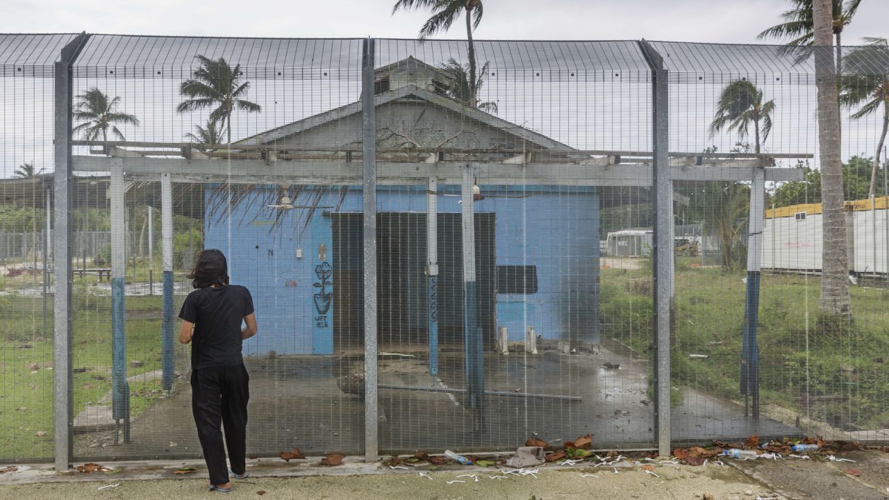 Asylum seeker Behrouz Boochani stands outside the abandoned naval base on Manus island, where he and other asylum seekers were locked up for the first three years of their dentention.