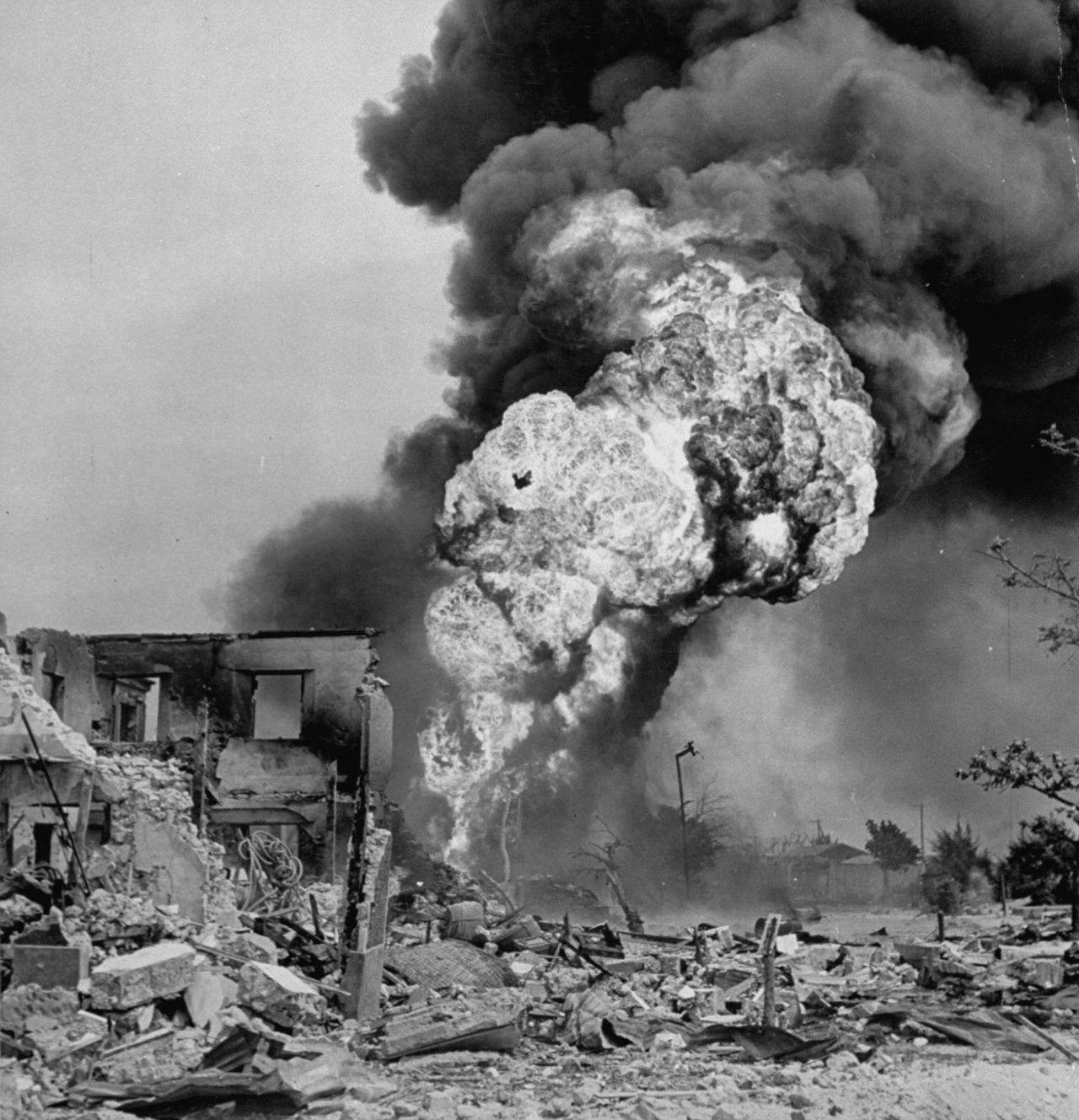 Smoke and flames pour from ruins of buildings hit during a fierce battle to take Saipan from occupying Japanese forces.