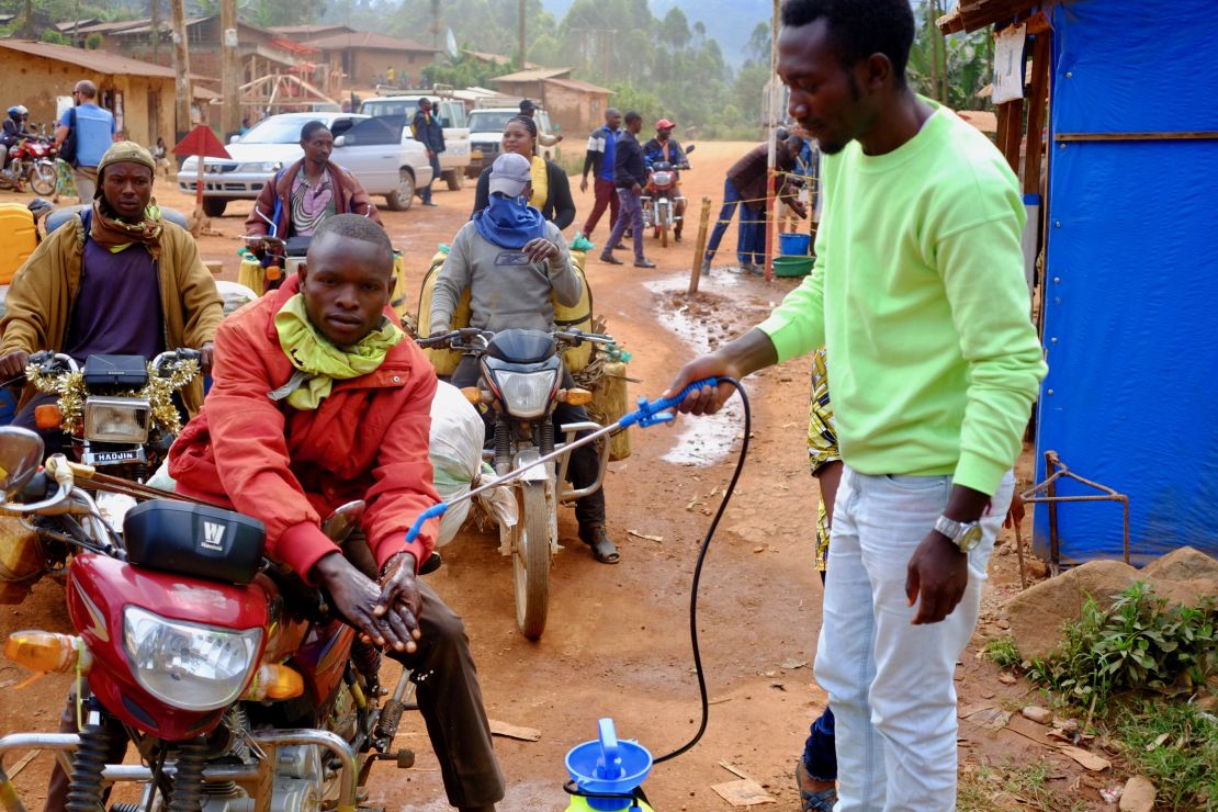 A motorcycle taxi driver gets his hands washed with a chlorine solution at a checkpoint between Beni and Butembo in eastern Democratic Republic of Congo. Temperatures are also checked and possible Ebola isolated. Still, many Ebola victims have travelled far distances and infected new parts of North Kivu and Ituri provinces.