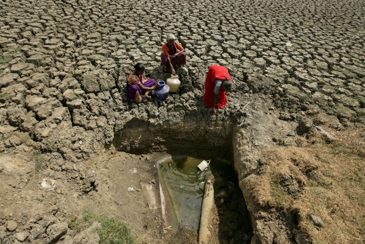 Women fetch water from an opening made at a dried-up lake in Chennai on June 11.