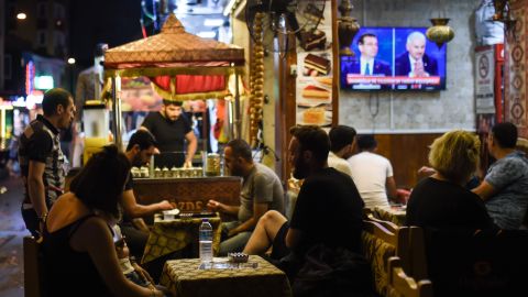 At an Istanbul café, people watch a live TV debate between Istanbul's main mayoral candidates.