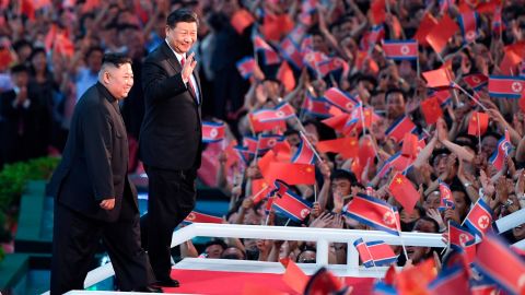 Spectators wave Chinese and North Korean flags as North Korean leader Kim Jong Un, left, and visiting Chinese President Xi Jinping attend a mass gymnastic performance at the May Day Stadium in Pyongyang, North Korea.