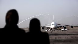 Iranian women watch an Airbus A380-800 airctaft of Emirates Airline being given a water cannon salute after landing at Tehran's IKA airport on September 30, 2014. Dubai's Emirates Airline made a one-off flight to the Iranian capital for the first time with its flagship Airbus A380 plane to celebrate its recent introduction of more flights on the route. AFP PHOTO/BEHROUZ MEHRI        (Photo credit should read BEHROUZ MEHRI/AFP/Getty Images)