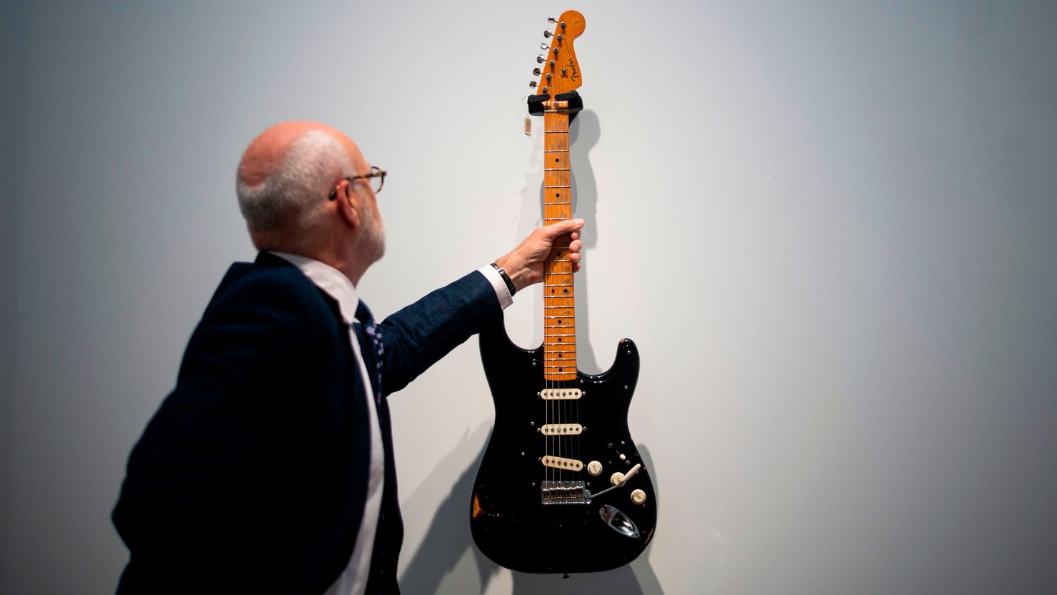 Kerry Keane, a musical instruments specialist for Christie's, holds Pink Floyd guitarist David Gilmour's 1969 Fender Stratocaster. Known as the "Black Strat," the guitar, which Gilmour used on some of the band's most famous recordings, auctioned for $3.9 million, a new record.