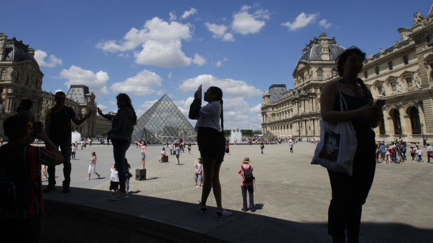Tourists pose for the pictures at the Louvre Museum during the first Summer hot day on June 21,2019 in Paris,France. (Photo by Paulo Amorim/NurPhoto via Getty Images)