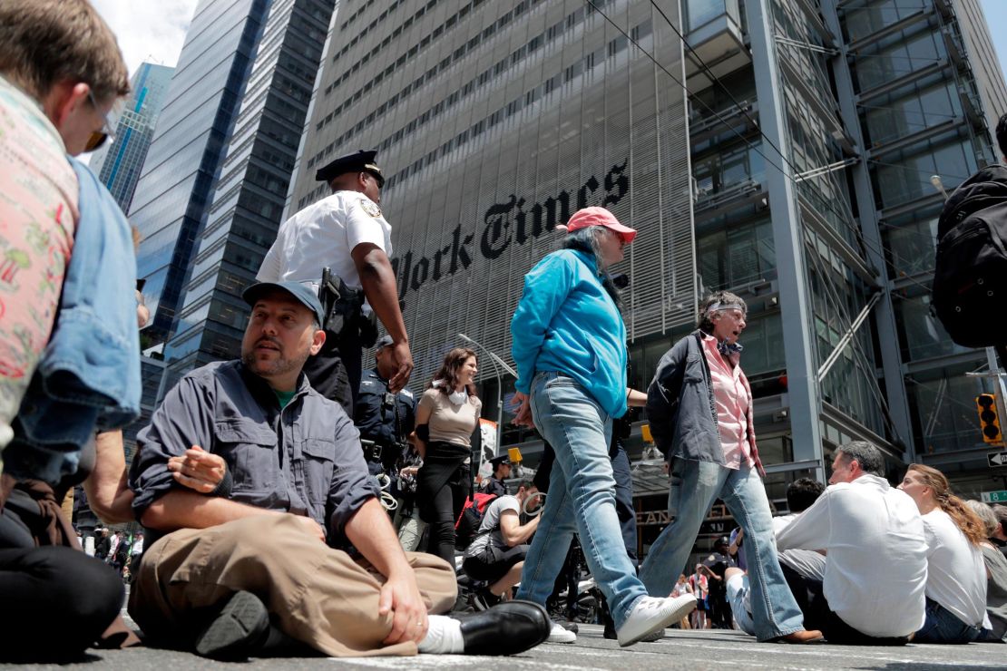 Activists sit on an intersection as others are taken into custody by New York Police officers during a climate change rally outside of the New York Times building.