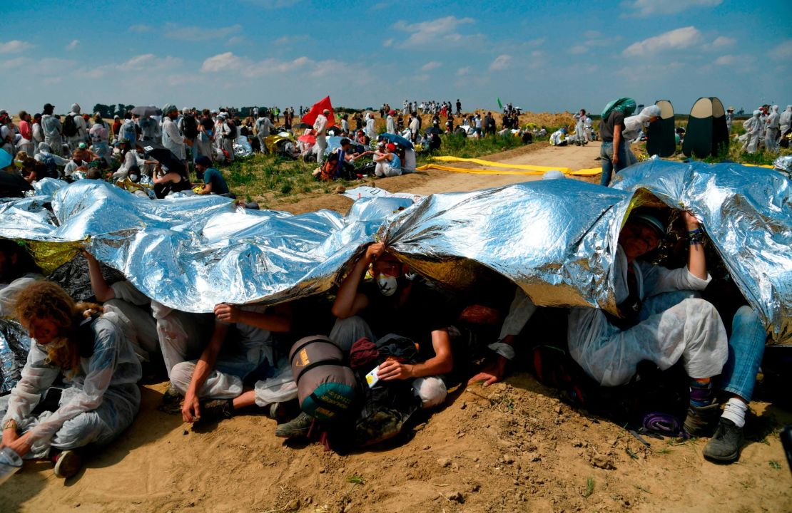 The activists sat beneath reflective blankets to protect themselves from the sun. 