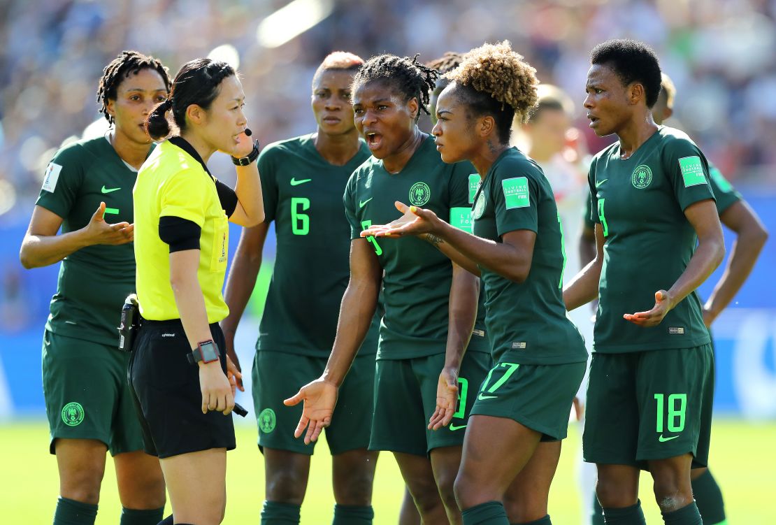 Nigeria players confront Yoshimi Yamashita after the referee awards a penalty to Germany. 