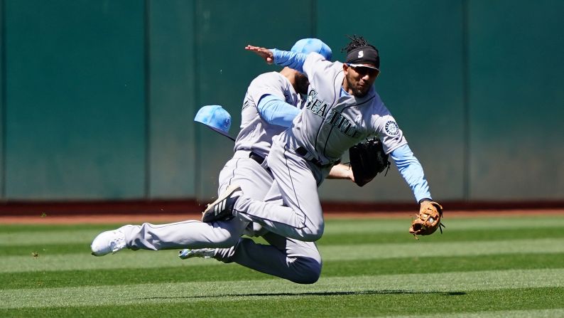 J.P. Crawford of the Seattle Mariners collides with teammate Mac Williamson while catching a fly ball during the sixth inning of a game against the Oakland Athletics in Oakland, California on June 16.