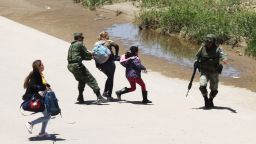 TOPSHOT - Mexican National Guard members prevent Central American migrants from crossing the Rio Bravo, in Ciudad Juarez, State of Chihuahua, on June 21, 2019. - Mexican President Andres Manuel Lopez Obrador suggested Friday he and US counterpart Donald Trump should hold their first meeting in September to review progress on the countries' recent migration deal. (Photo by HERIKA MARTINEZ / AFP)        (Photo credit should read HERIKA MARTINEZ/AFP/Getty Images)