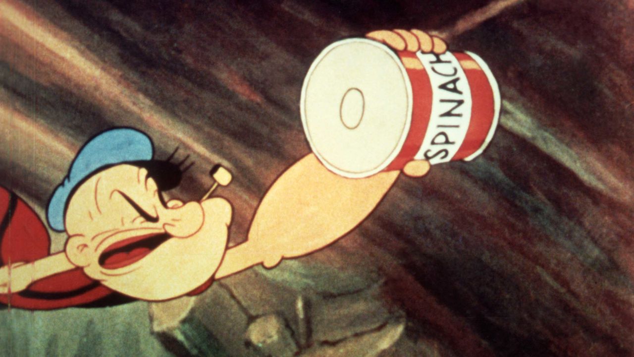 Popeye reaches for a can of spinach in a still from an unidenitified Popeye film, c. 1945. (Image by Paramount Pictures/Courtesy of Getty Images)