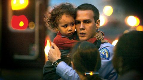 In this November 17, 2003 photo, St. Louis Police officer Michael Langsdorf comforts 2-year-old KeAndre Colenburg who had just been dropped by his father from the third floor roof of a house after the house caught on fire (J.B. Forbes/St. Louis Post-Dispatch via AP)
