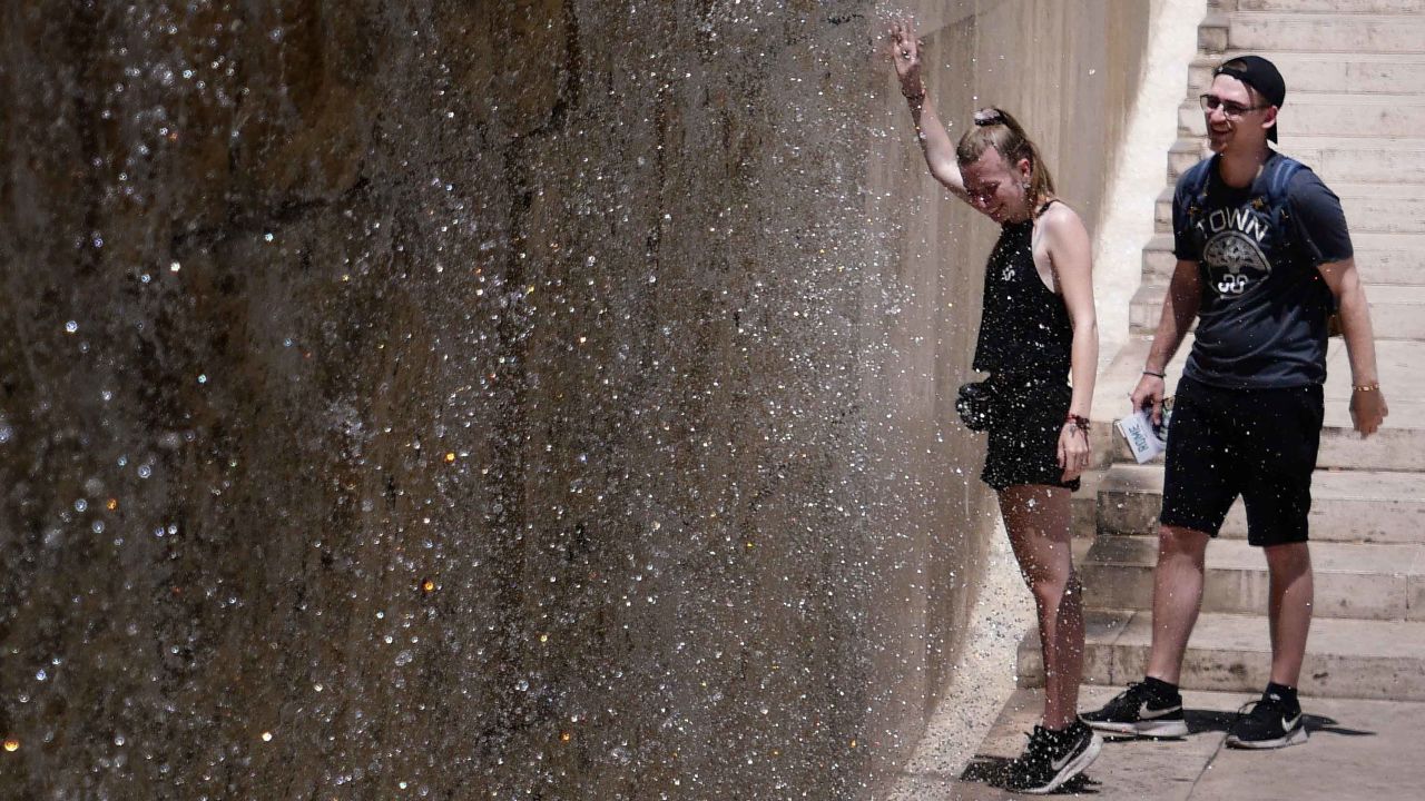 People seek refuge from the heat in a fountain in Rome.